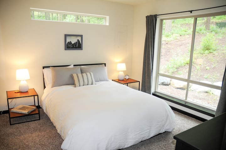 Spálňa #2: matrac z pamäťovej peny Queen, komoda, šatník, stojan na batožinu a veľké okná.