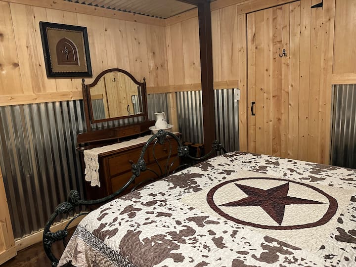 The master bedroom is small with a queen bed, dresser and night stands.