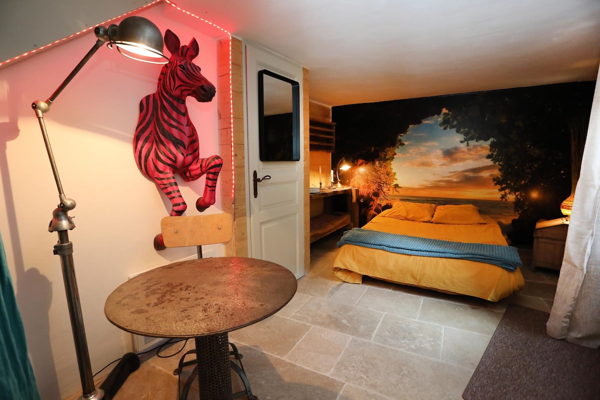 Спалня на приземния етаж с изглед към всекидневната. Оригиналната му декорация ще ви отведе надалеч. 