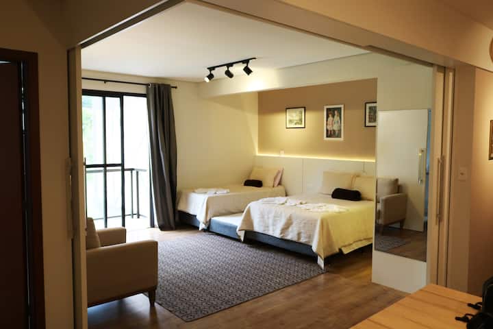 Opći pogled na prostoriju s velikim zrcalom, bračnim krevetom te jednostrukim i sklopivim ležajem. 