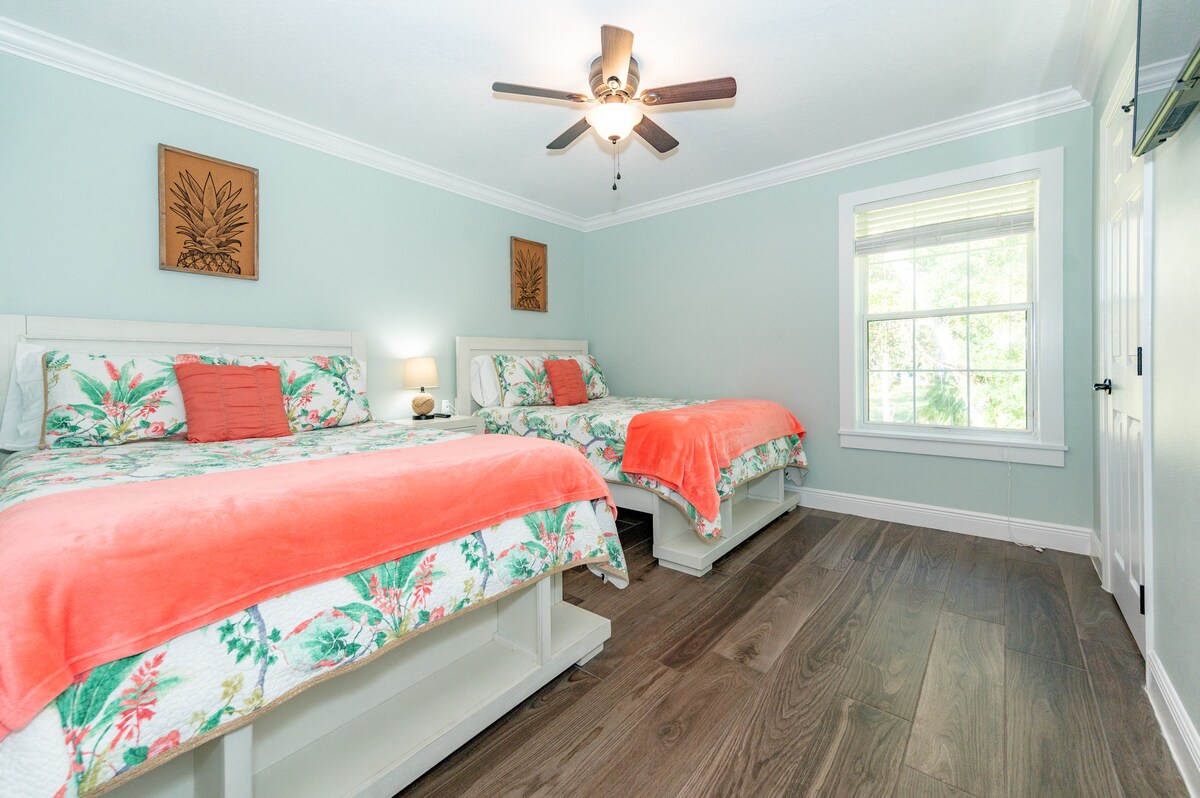 חדר שינה לאורחים עם 2 מיטות מלאות, טלוויזיה עם מסך שטוח וחדר ארונות.  