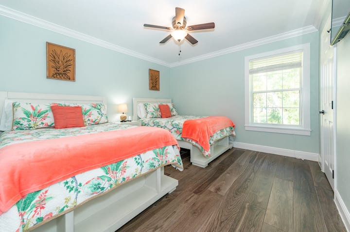 Spálňa pre hostí s 2 manželskými posteľami, televízorom s plochou obrazovkou a šatníkom.  