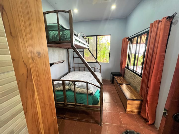 Dormitorio 3. Cama tamaño queen en la parte inferior con una cama individual en la parte superior. Refrigerador de tamaño completo, (no se muestra en la imagen), aire acondicionado, baño con ducha adjunta. Vistas al mar y acceso directo a la piscina y a la cocina al aire libre.
