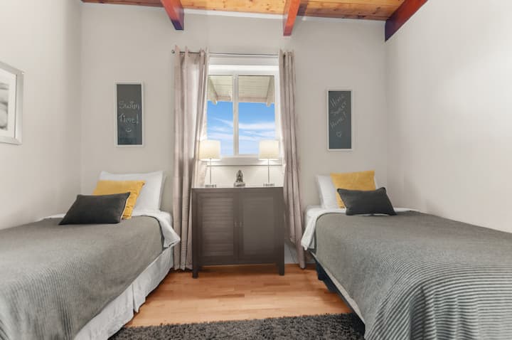 El dormitorio #3 tiene 2 camas individuales, colchón y sábanas de primera calidad, pisos de madera, techo de viga de madera, armario, ventilador y aire acondicionado.