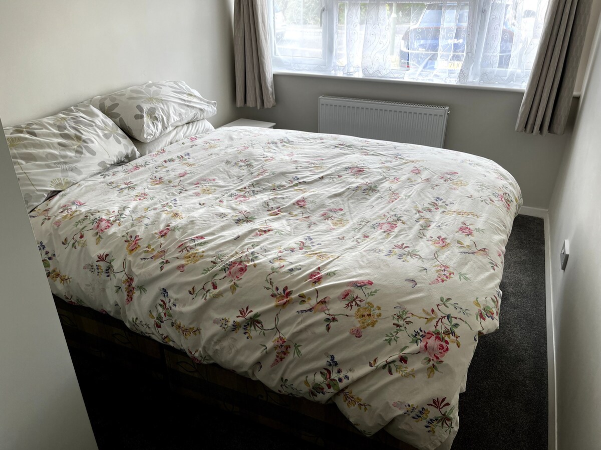 Spálňa s manželskou posteľou, toaletou a umývadlom v apartmáne.