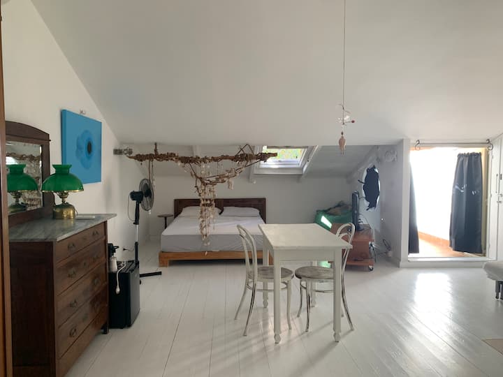Un dormitorio con una cama doble, cómoda, armario y una ventana a la terraza.