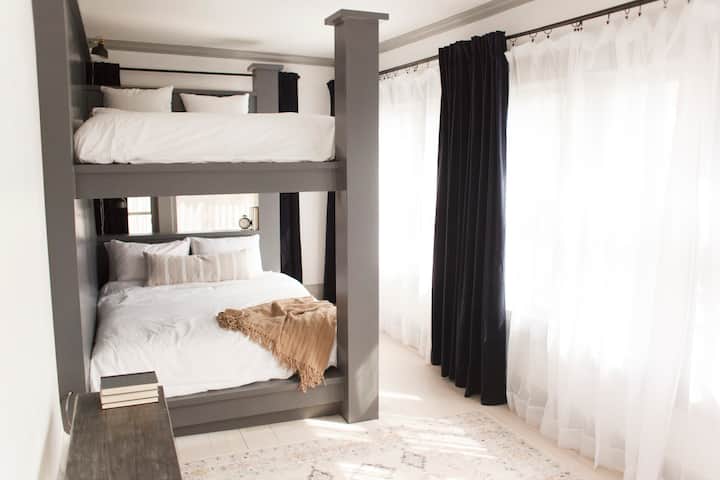 DOWNSTAIRS:
This beautiful light-filled bunk room has 2 queen-sized bunk beds to accommodate 4 people. This room is adjoined with the black & white tiled bathroom.