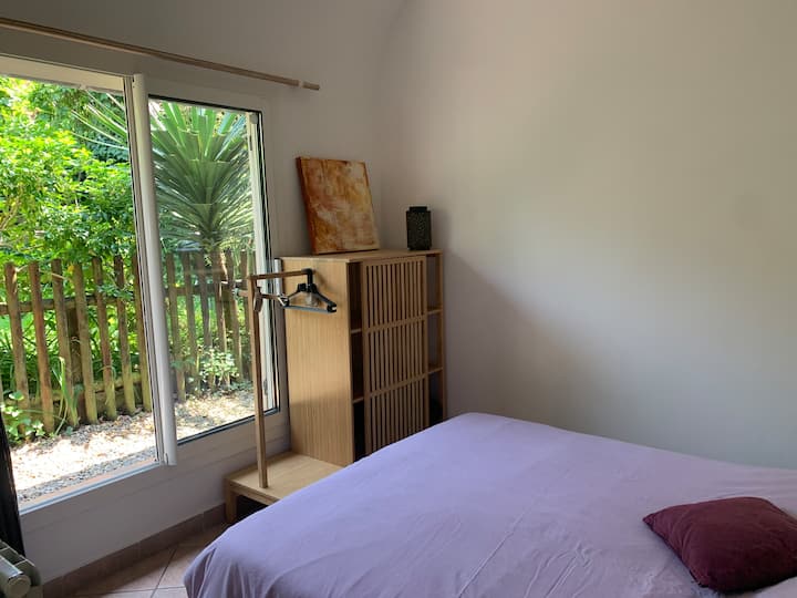 غرفة نوم مع نافذة كبيرة تطل على الحديقة