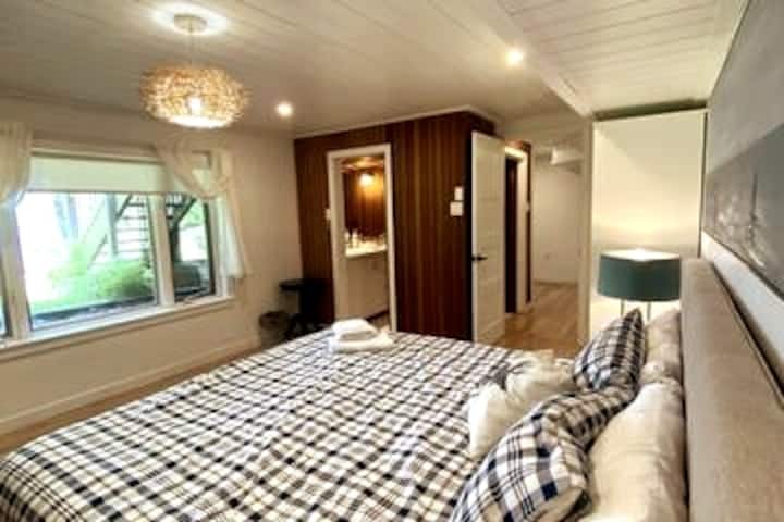 חדר שינה קינג שעודכן לאחרונה לעונת 2023 עם מזרן אנדי וחלונות גדולים המציעים נוף מרהיב לאגם