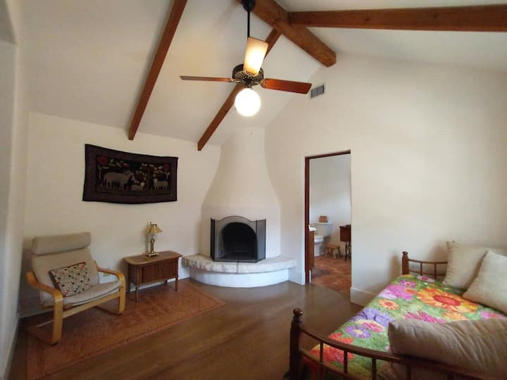 Pueblo style fireplace in bedroom with trundle bed. Connects to main bathroom.