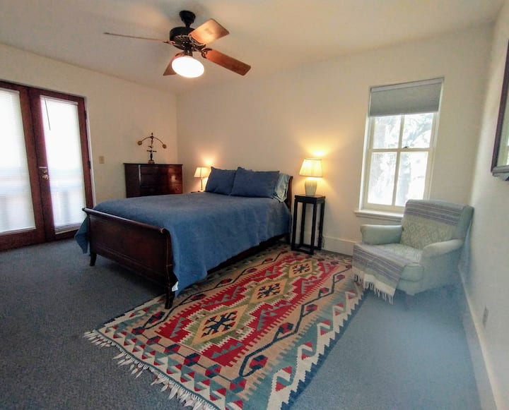 First of three upstairs bedrooms has a full-sized bed and doors to the balcony
