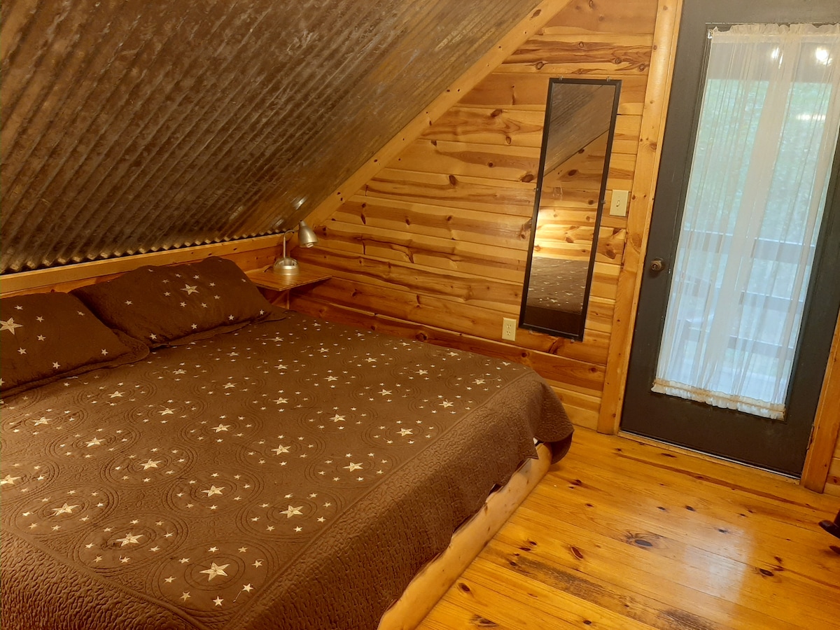 Upstairs king bed, full length mirror. Exterior door leading out to outside small balcony & stairs.