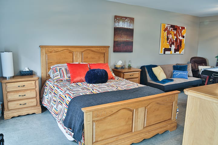 ห้องนอน 1 ที่ชั้นล่าง 1 เตียงควีนไซส์และโซฟาเบดและห้องน้ำพร้อมฝักบัวอ่างล้างหน้าและโถสุขภัณฑ์