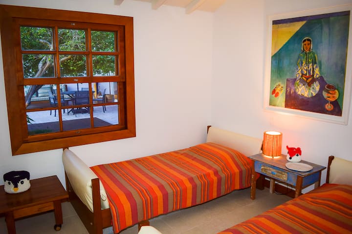 جناح بسريرين مفردين، يمكن استخدامه أيضًا كغرفة للأطفال، مع إطلالات على الفناء وحمام السباحة.