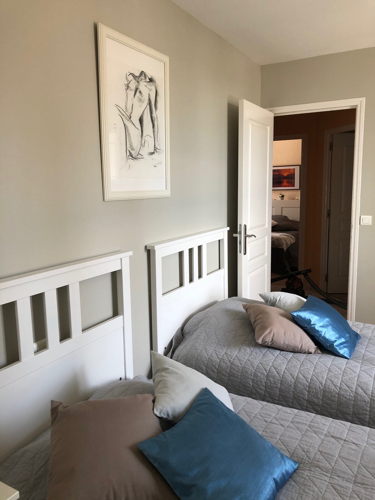 Dhomë gjumi gri në katin e sipërm; tualet dhe banjë në tokë.