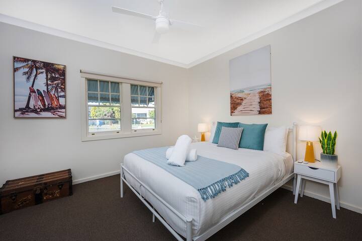 The naturally-lit master bedroom comes complete with a comfortable queen bed, ceiling fan and an en-suite bathroom.
