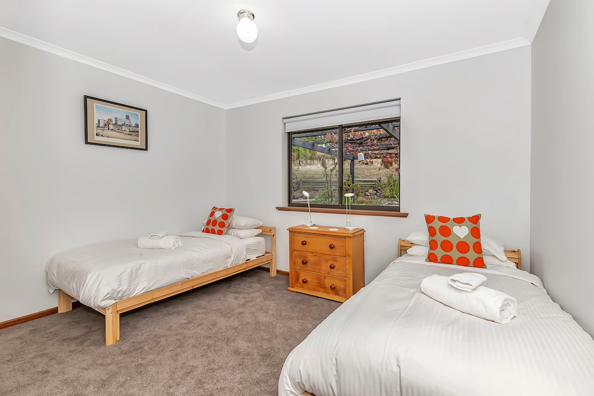 The fourth bedroom has views out to the back patio, and sleeps two in single beds.