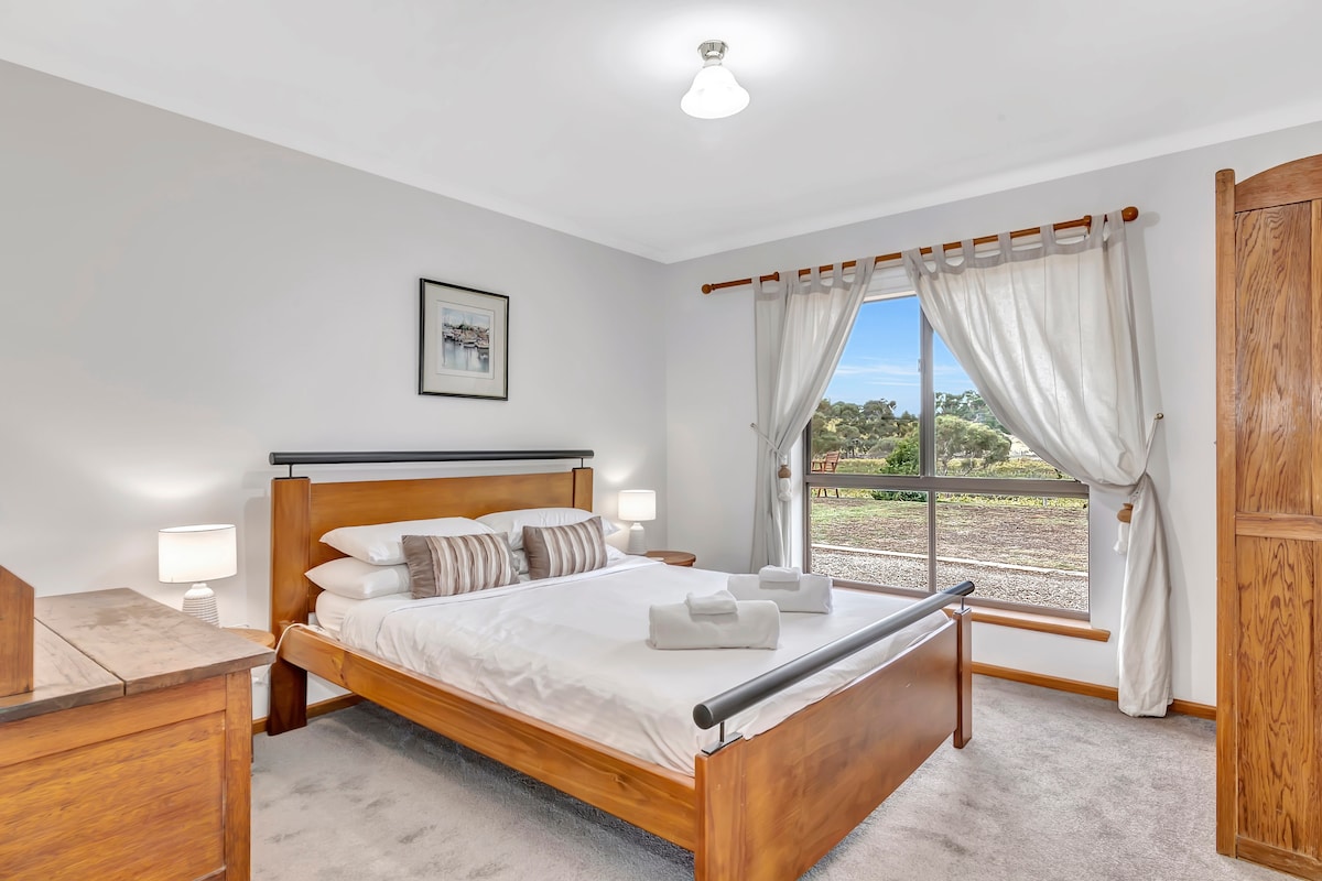The second bedroom overlooks the sprawling vines, offering a double bed and plenty of storage. 