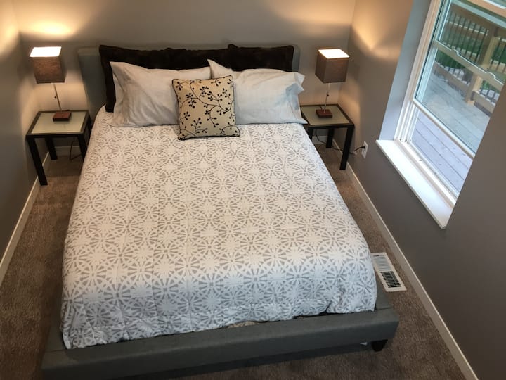 There are three private queen bedrooms.  This one is on the main level and has views facing the lake.   This bed is made up with sheets for your use.
