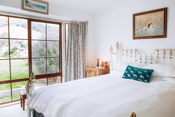 Habitación romántica con cama tamaño Queen y vistas al jardín.