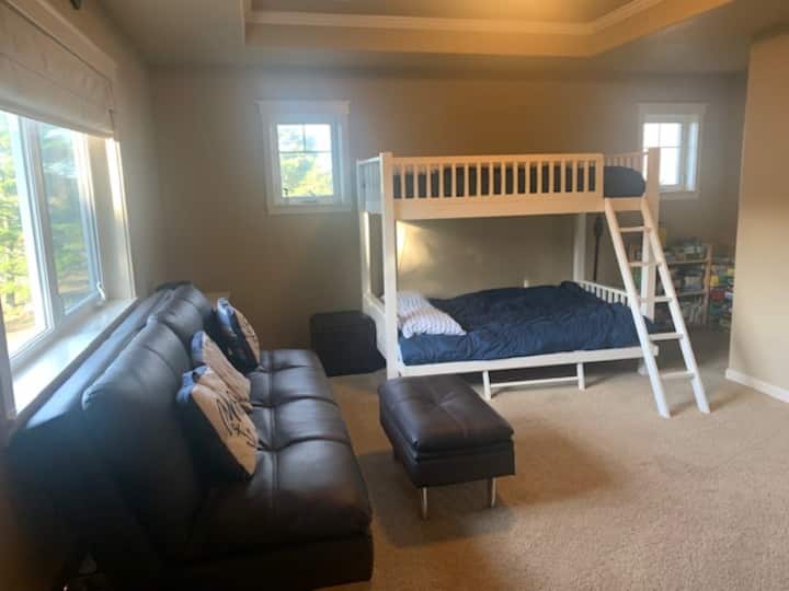 Bedroom with Bunk beds (double on bottom) and leather sleeper sofa.  Games, puzzles, books, tv and game system.