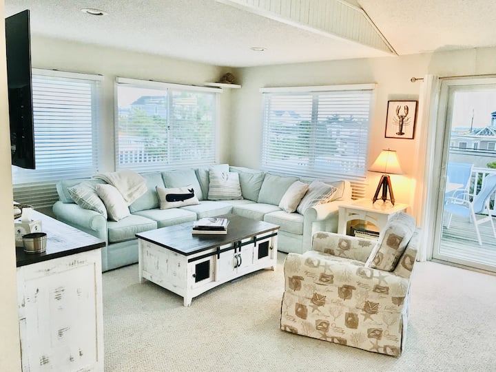 منطقة معيشة واسعة مع أريكة صغيرة وكرسي هزاز. تلفزيون ذكي ذو شاشة مسطحة 55بوصة وطاولة قهوة وطاولة أريكة مليئة بالكتب والألعاب والألغاز وطابعة. (الطرف الشمالي من الغرفة 28بوصة). توفر الأبواب المنزلقة إمكانية الوصول إلى السطح.