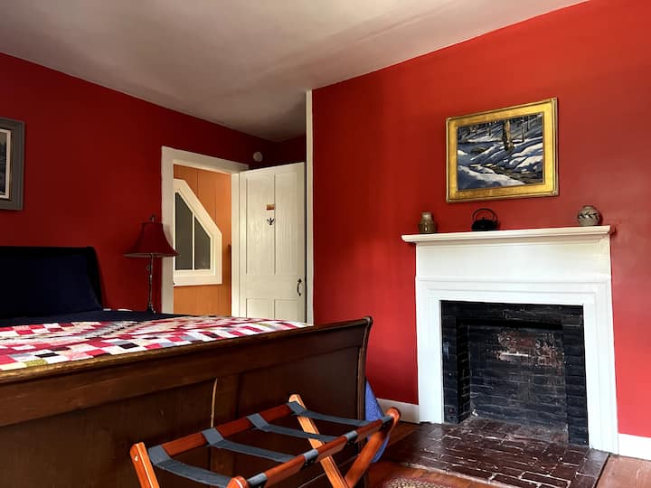 Chumba chekundu chenye kitanda cha malkia.