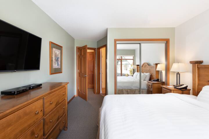 חדר השינה הראשי בקומה השלישית עם טלוויזיה חכמה וחדר רחצה צמוד. 