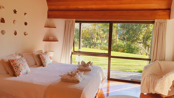 Зашеметяваща родителска спалня със суперголямо двойно легло, самостоятелна баня и красива гледка през тревните площи към реката. 