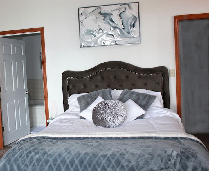 Dhomë gjumi kryesore me pamje nga liqeni, verandë private dhe banjë spa. 