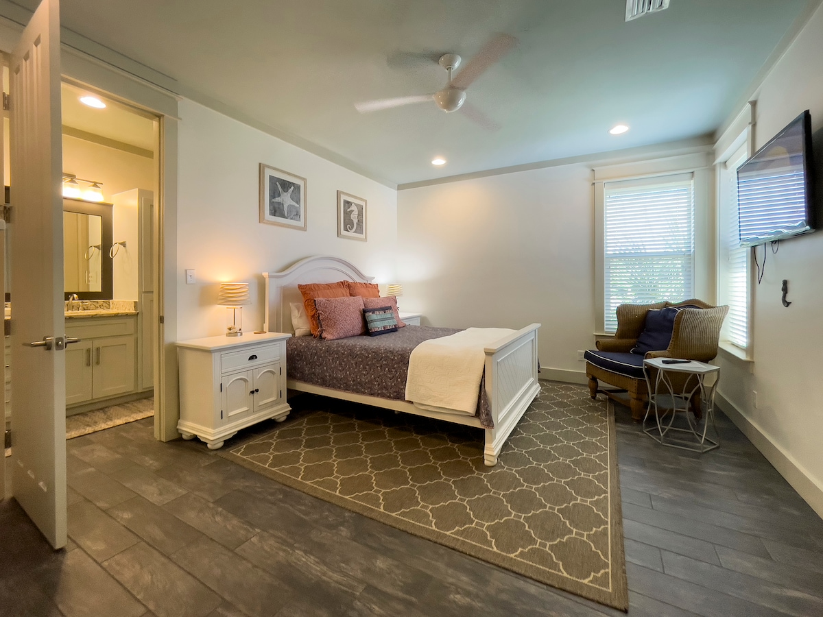 غرفة نوم كوين مع إمكانية الدخول إلى حمام مشترك يحتوي على مرآة مزدوجة وحوض استحمام