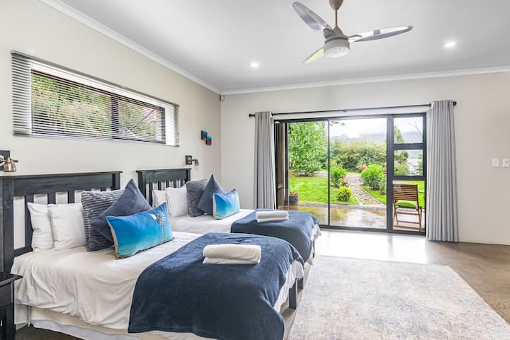 Second bedroom with two single beds (with electric blankets) and a bunk bed. Ceiling fan and small mobile heater. Leading out onto the garden