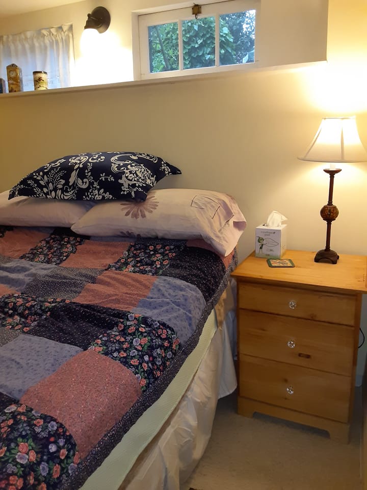 سرير كامل الحجم للضيوف وخزانة ملابس صغيرة بجانب السرير