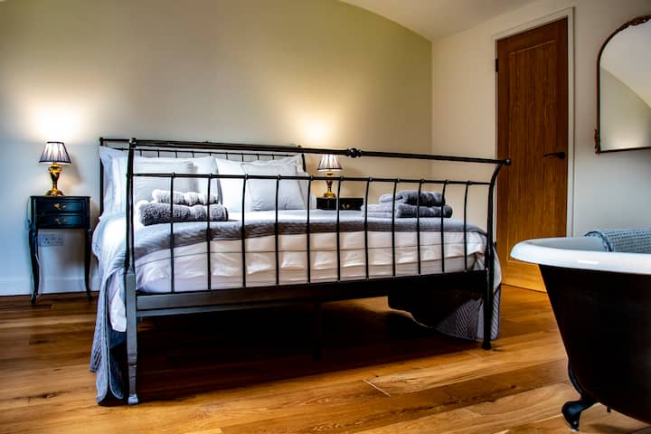 La chambre principale dispose d'un lit king size avec un matelas en mousse à mémoire de forme et une literie en coton égyptien pour assurer une nuit de sommeil paisible. Bien que nous ne puissions pas garantir que les hiboux ne chantent pas à vous. 

Il dispose également d'une salle de bain attenante et d'une magnifique baignoire.