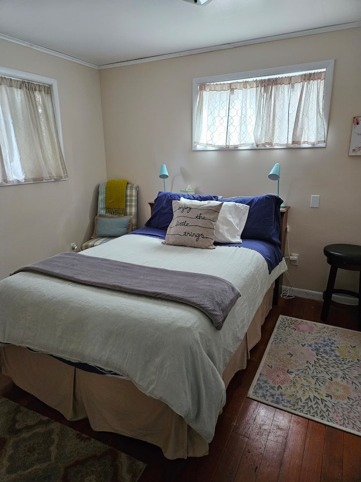 חדר שינה קדמי נעים ובהיר עם מיטה מלאה.