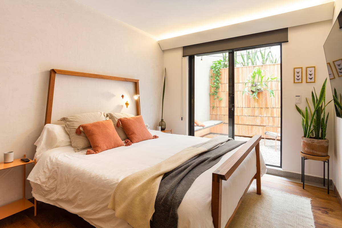 El dormitorio cuenta con una cama tamaño king diseñada a medida (hecha de madera dura tropical) que se abre al patio privado. Un televisor de58pulgadas te permite disfrutar de una película antes de acostarte. Los apagones te permitirán dormir hasta tarde bloqueando la luz de la mañana.