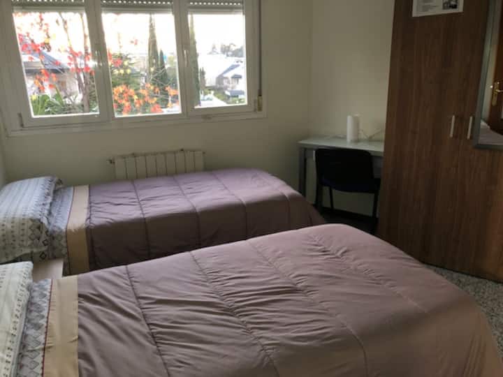 ห้องพักพร้อมเตียงเดี่ยว 2 เตียงและโต๊ะทำงาน
ห้องนอนพร้อมเตียงแฝด 2 เตียงและพื้นที่ทำงาน