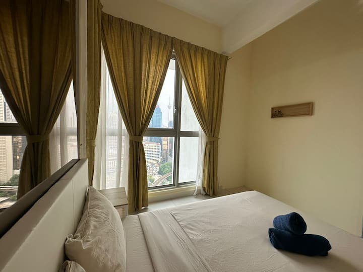 חדר שינה שלישי עם מיטת קווין סייז אחת ונוף למגדל KLCC ו - KL.