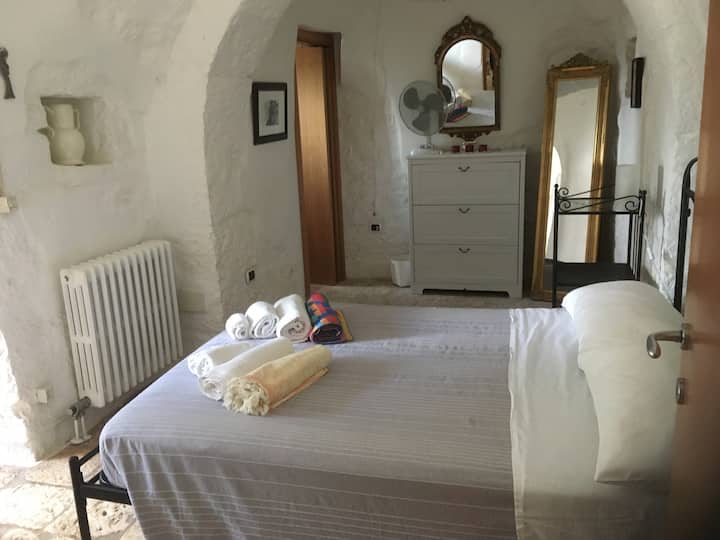 The Trullo bedroom with the door open to the patio in front of the Trullo 