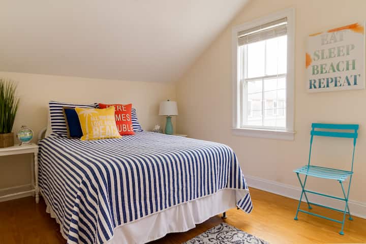 Queen size bed in light filled room. 