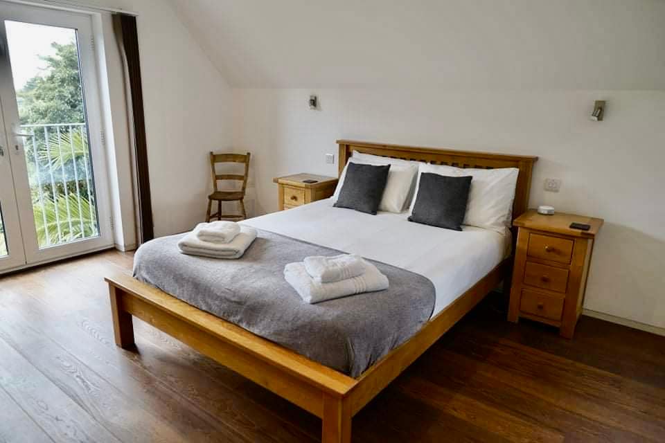 Veľká spálňa s manželskou posteľou veľkosti King, vlastnou kúpeľňou s balkónom a výhľadom na more