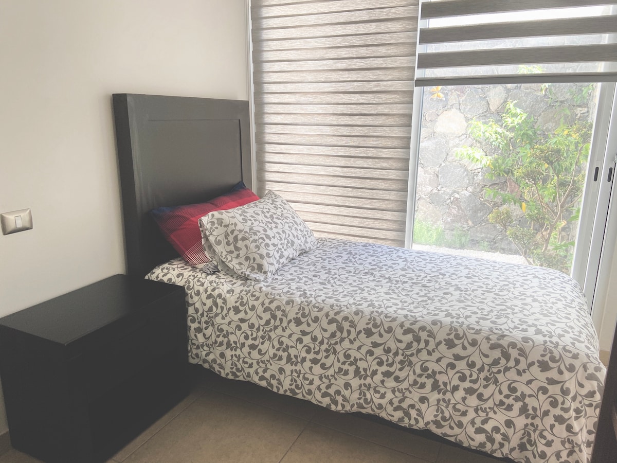 חדר עם מיטת יחיד וחדר רחצה נפרד.