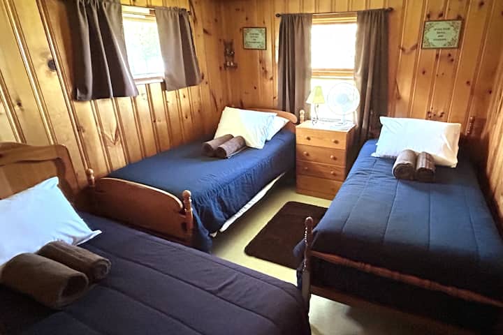 第二间卧室配有三张单人床和一个梳妆台。