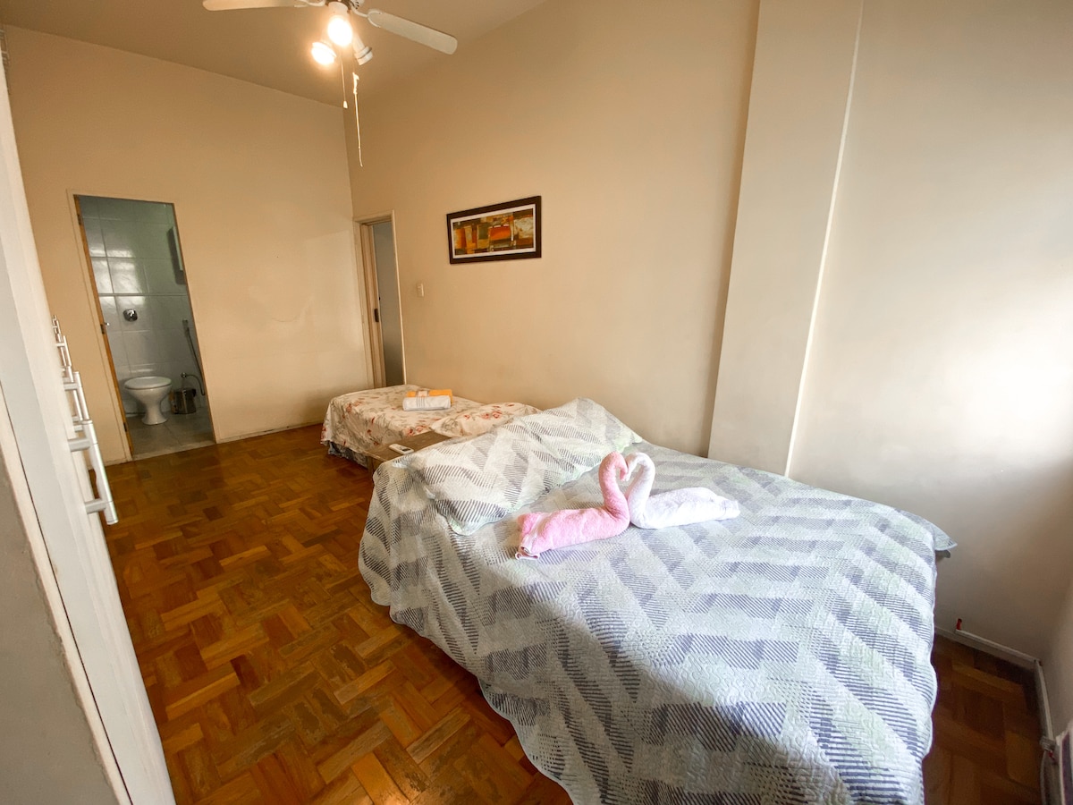 חדר שינה עם מיטה זוגית אחת, מיטת יחיד אחת שמתחלקת ושני מזרני יחיד על הרצפה