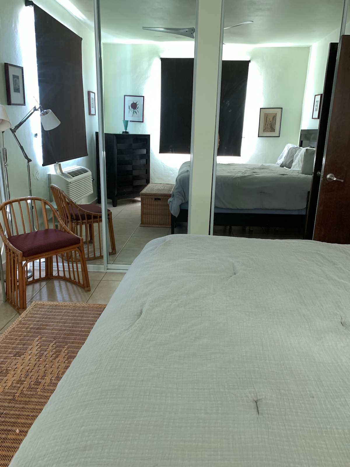 Grande chambre avec lit King Size, coin salon et portes de placard en miroir. 