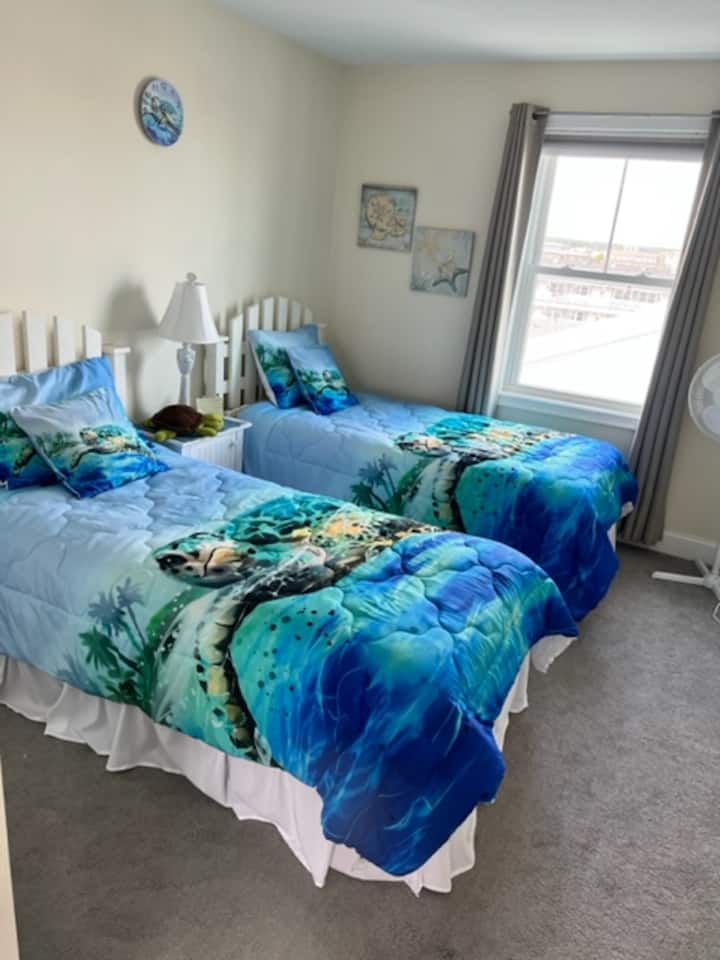 slaapkamer met twee eenpersoonsbedden boven met jaloezieën en verduisterende gordijnen