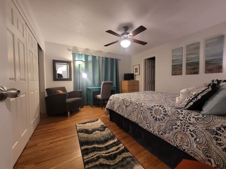 Dormitorio principal queen con baño privado, escritorio y viuda grande abierta al patio trasero.