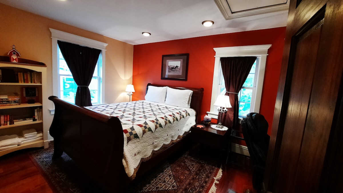 Chumba cha machungwa - chumba cha kulala cha ghorofani na kitanda cha malkia na mapazia ya rangi nyeusi