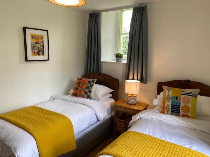 Schlafzimmer 2 mit zwei Einzelbetten und doppelten Fenstern.