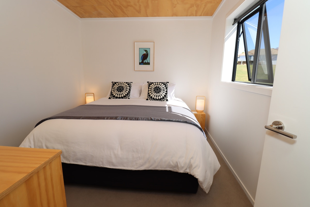 Bedroom with king size bed and afternoon sun.